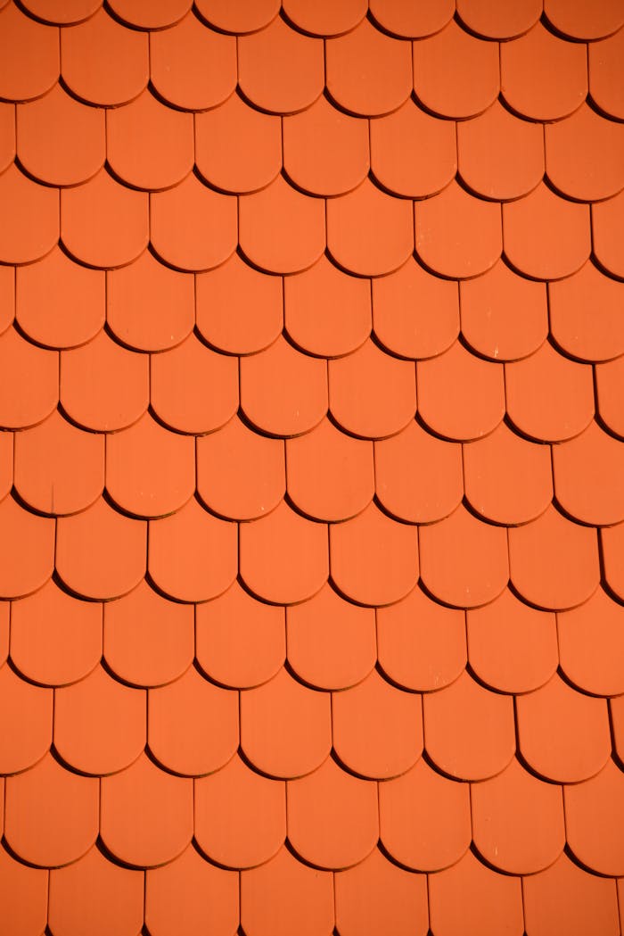 Services Bright orange roof tiles arranged in a seamless repetitive pattern, perfect for backgrounds and designs.