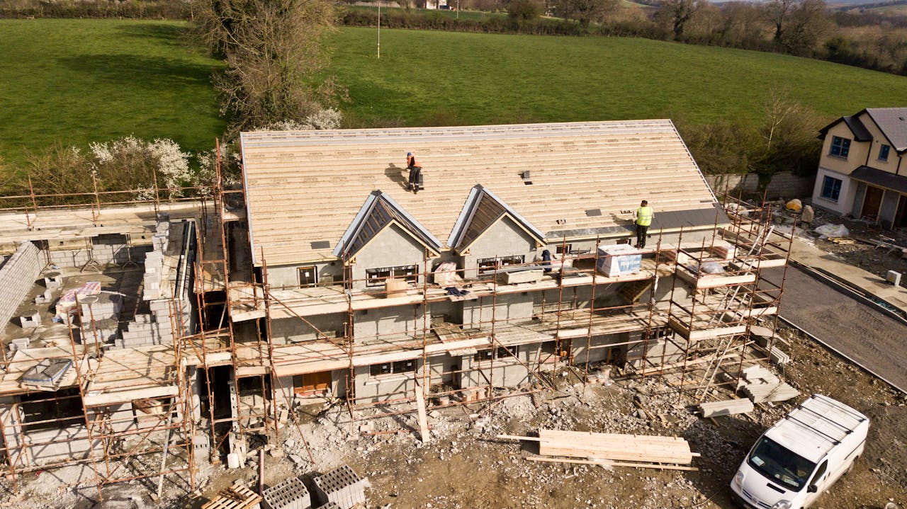 Services Aerial shot of a house under construction in Clonmel, Ireland. Workers on the roof.